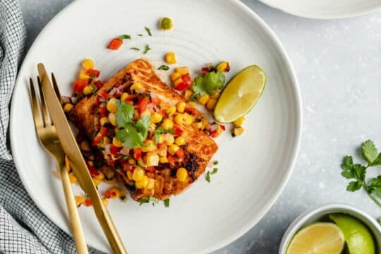 Cooked fish plated with corn salsa.