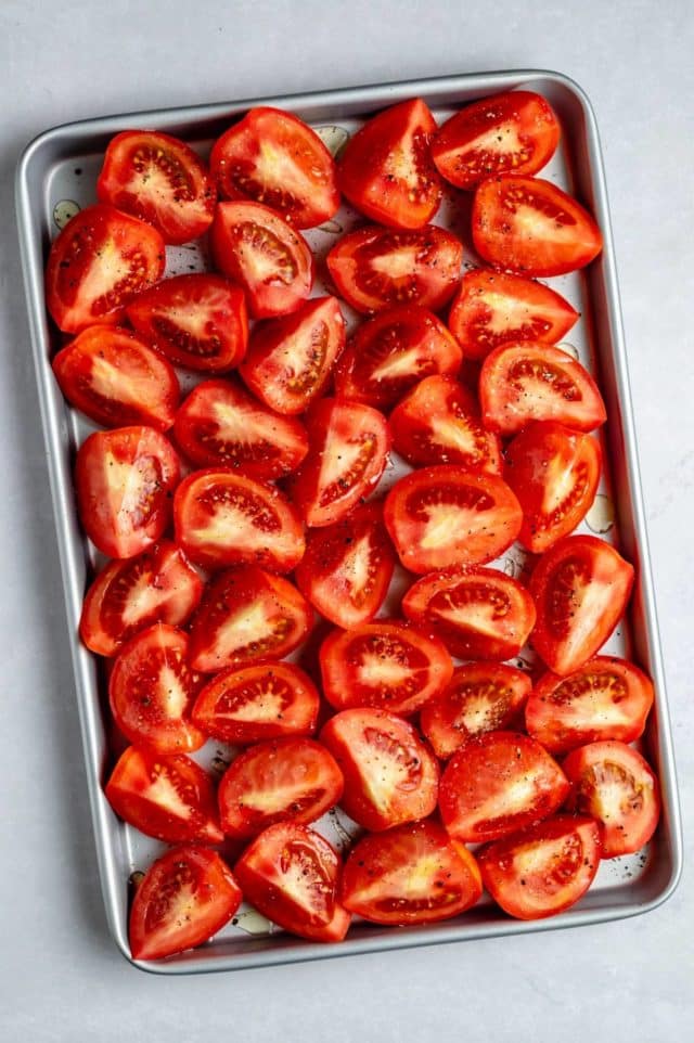 fresh tomatoes cut and placed on a baking sheet pan