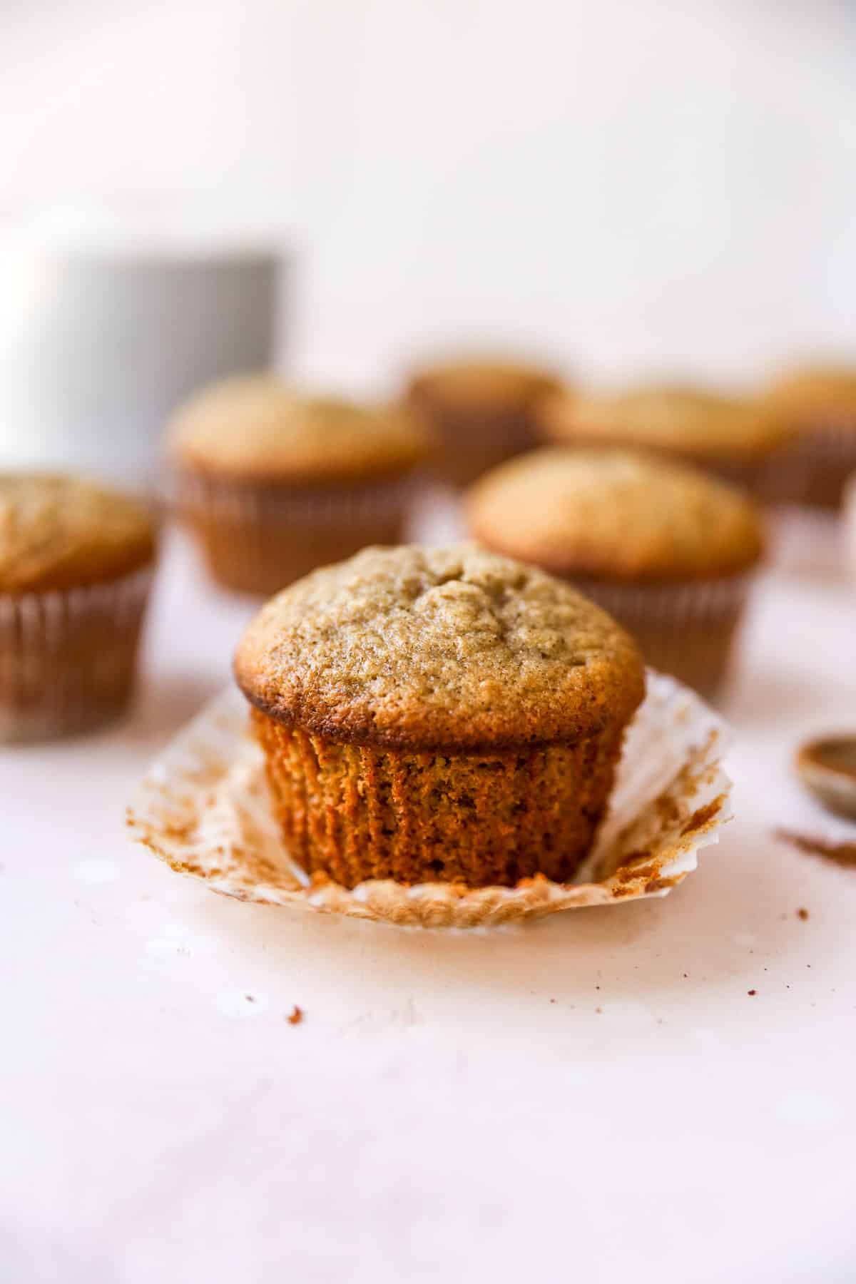 Unwrapped banana muffin near other muffins.