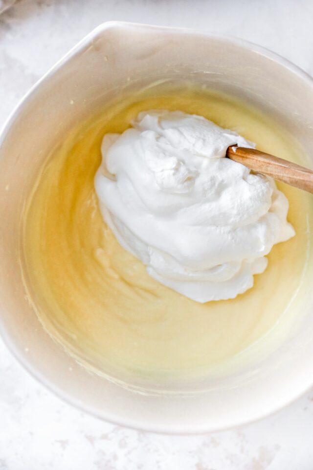 Stirring whipped cream into banana pudding.