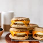 stacked breakfast sandwiches made with sausage, egg and cheese on an English muffin
