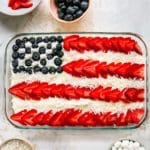 Flag cake decorated with strawberries and blueberries.