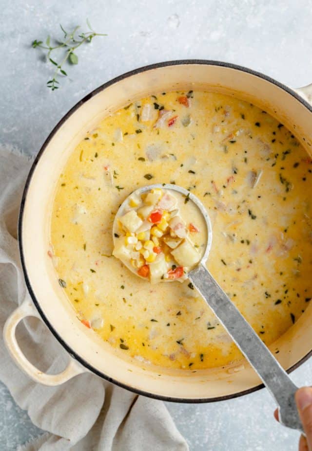 creamy corn chowder in a large pot with a ladle 