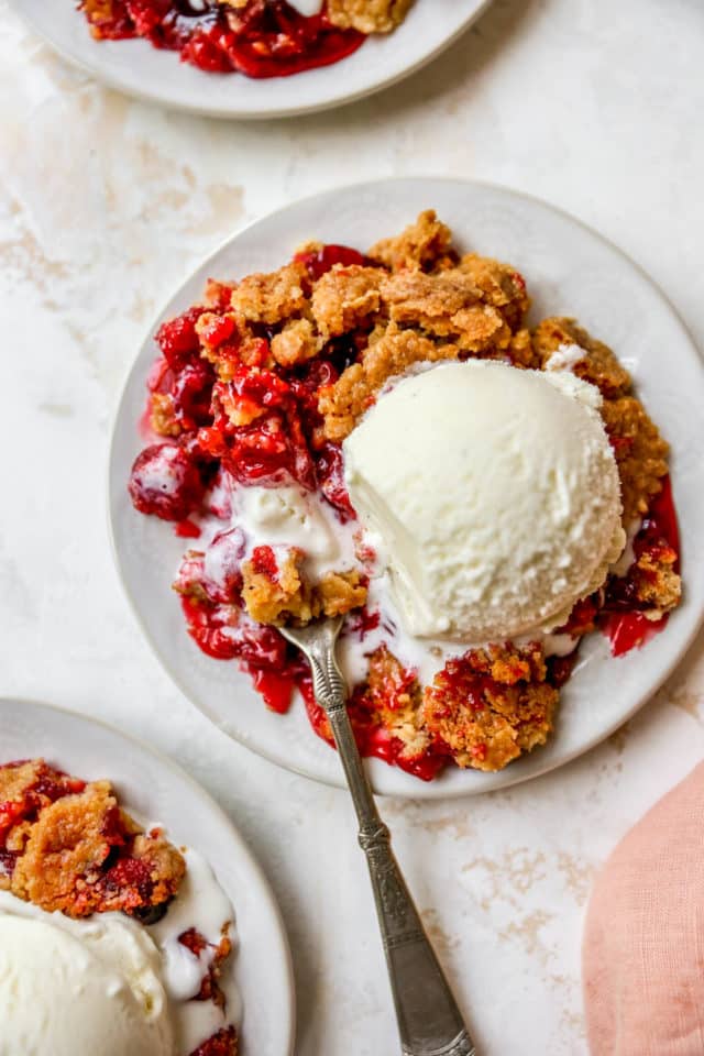 serving of cherry dump cake topped with a scoop of vanilla ice cream