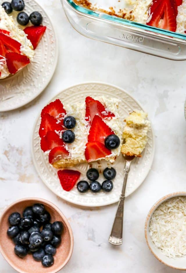 serving of yellow cake topped with strawberry slices and blueberries