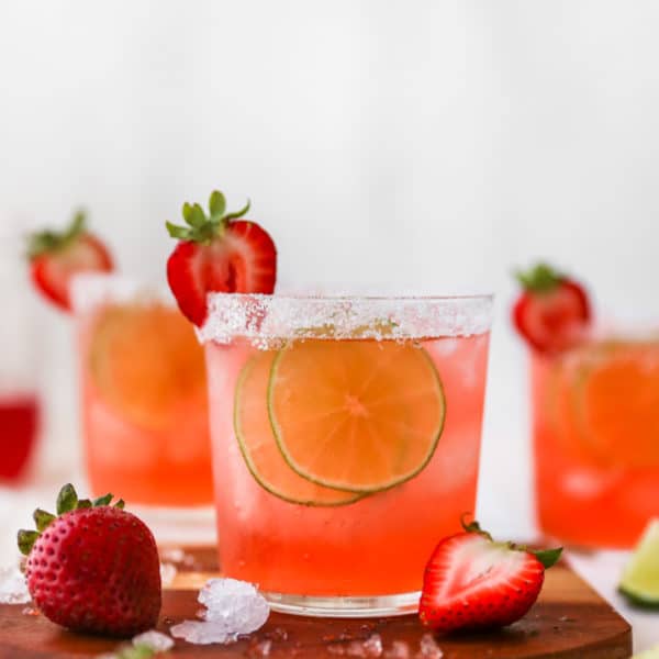 strawberry margarita garnished with lime slices and fresh strawberries