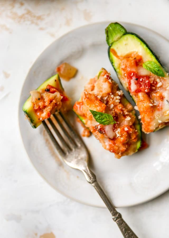stuffed zucchini on a plate with a bite on a fork