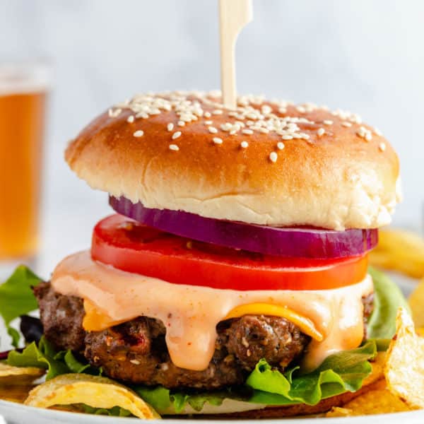 healthy burgers topped with cheese, burger sauce, tomato and red onion