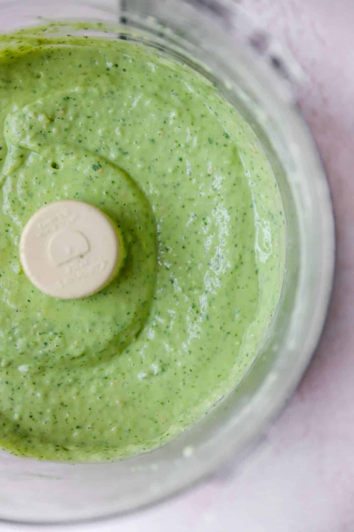 Creamy avocado dressing in a food processor.