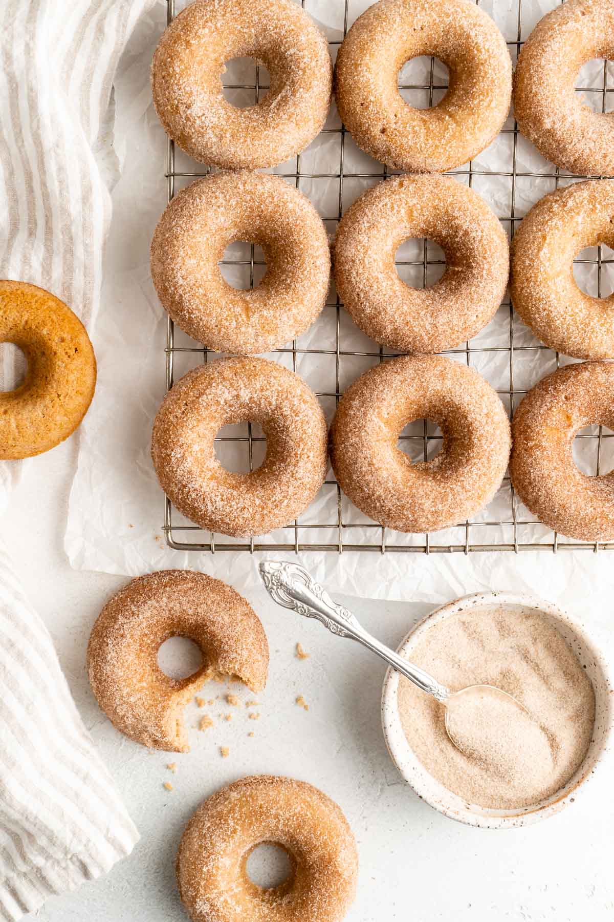 Donuts with cinnamon sugar coating on a wire cooling rack.