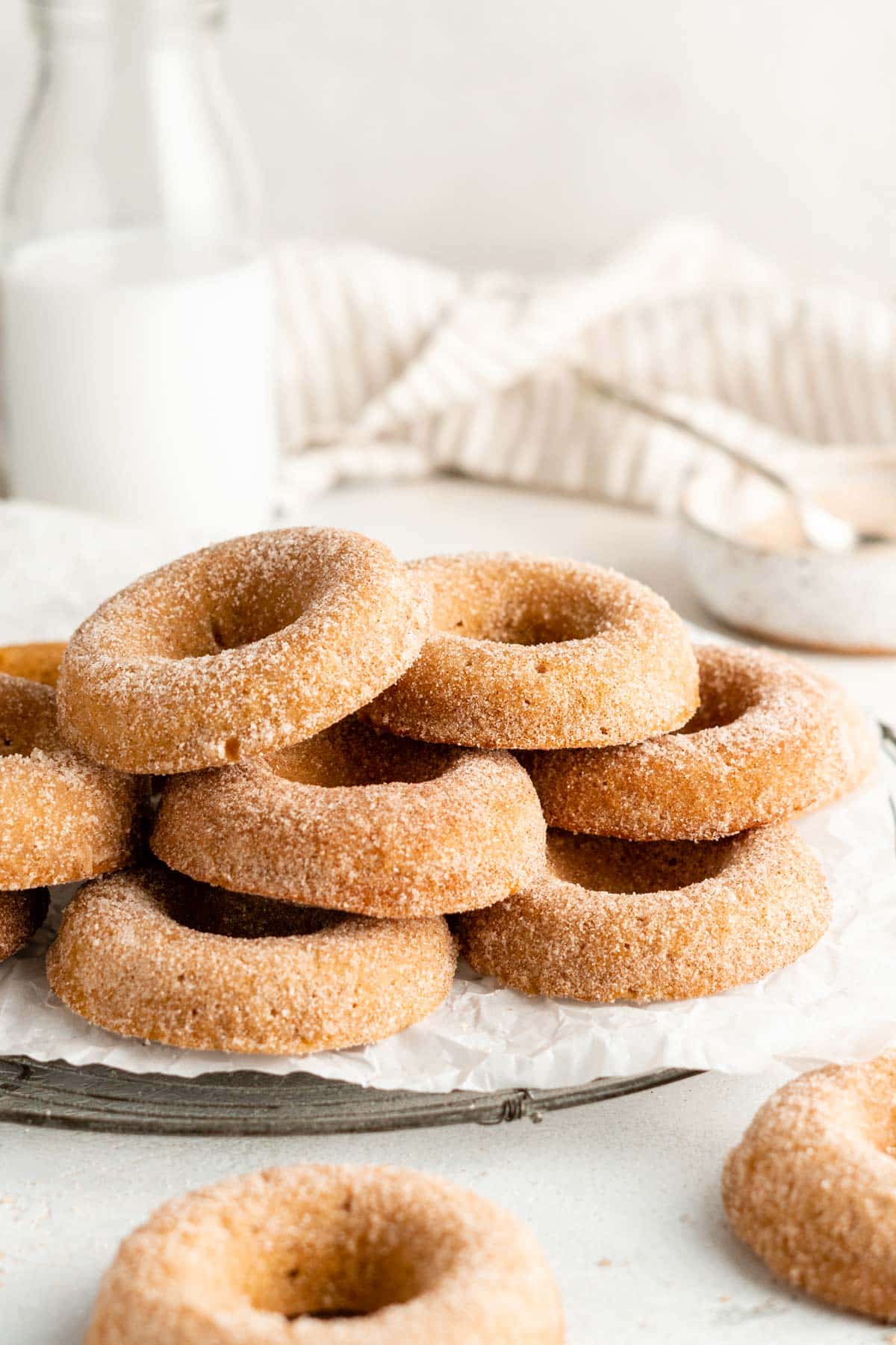 Cinnamon sugar donuts stacked on parchment paper.