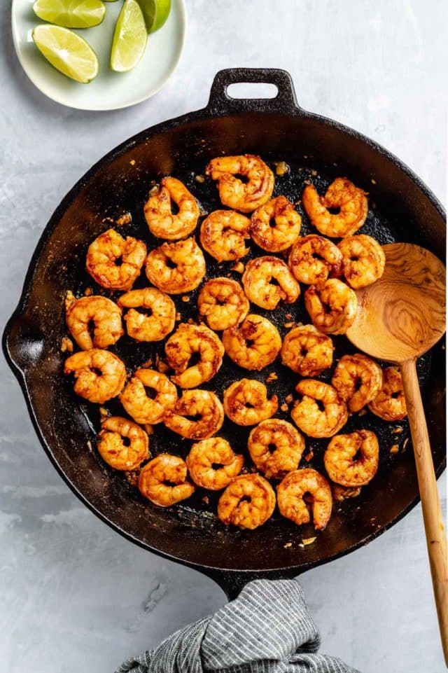cooking seasoned shrimp in a cast-iron skillet