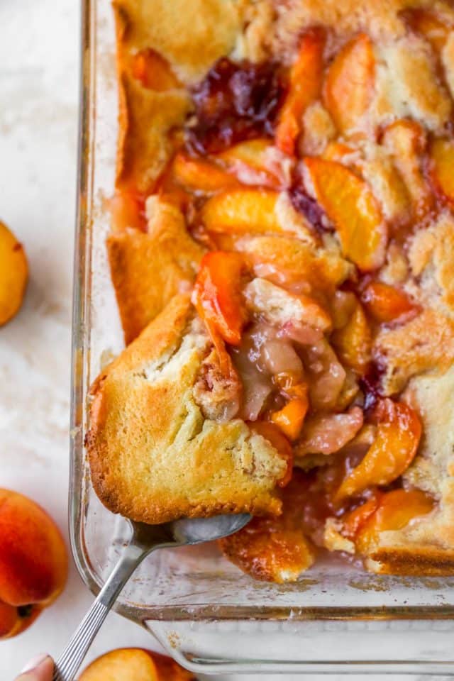serving peach cobbler out of a large baking dish