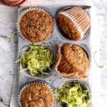 zucchini muffins in a muffin pan with shredded zucchini