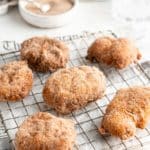 Cinnamon sugar apple fritters on a cooling rack.