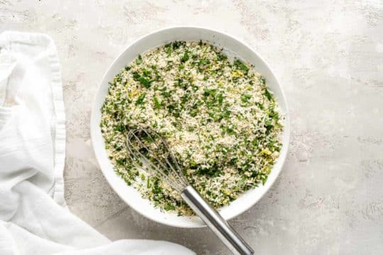 a mix of panko breadcrumbs and fresh herbs in a white bowl