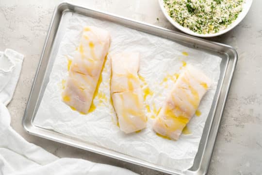 halibut fillets drizzled with olive oil on a sheet pan