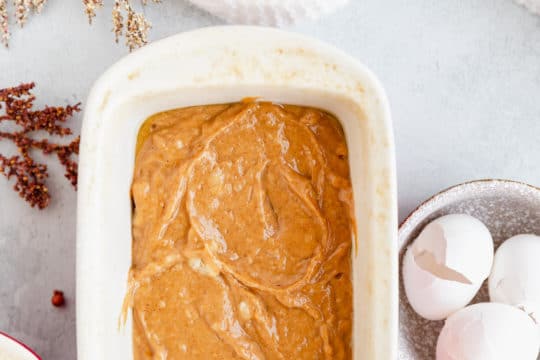 add pumpkin banana bread batter to a loaf pan