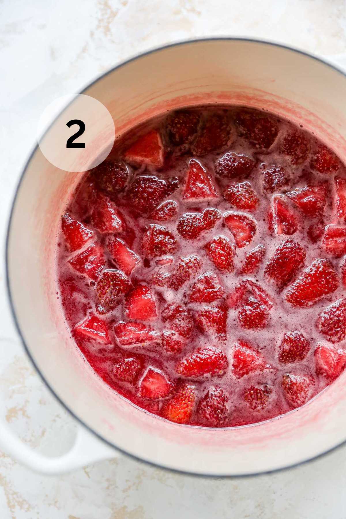 Strawberries simmering in a pot.