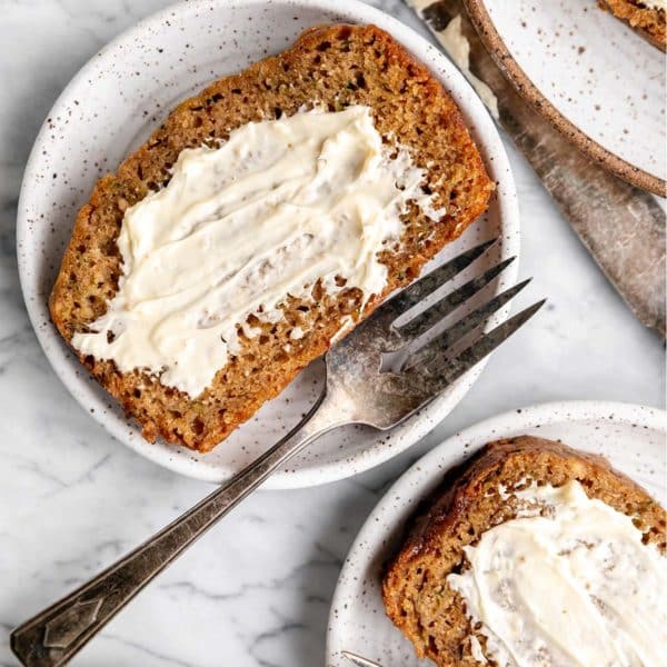 slices of zucchini bread with butter served on small white plates