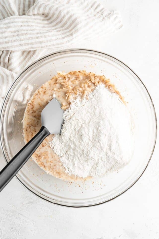 Stirring flour into wet batter ingredients.