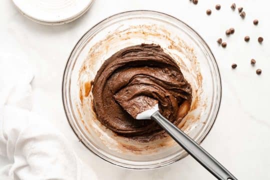 mixing chocolate brownie batter in a large mixing bowl