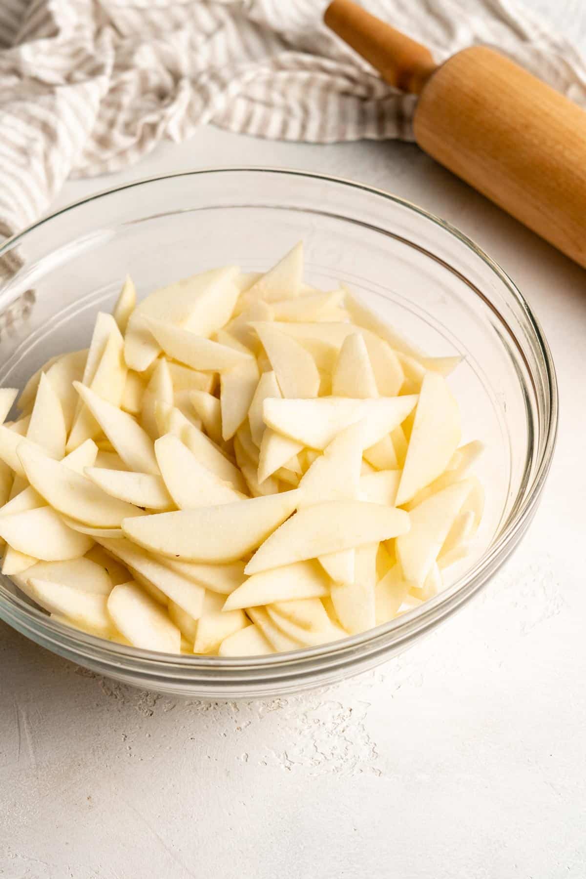 sliced and peeled pears in a glass mixing bowl