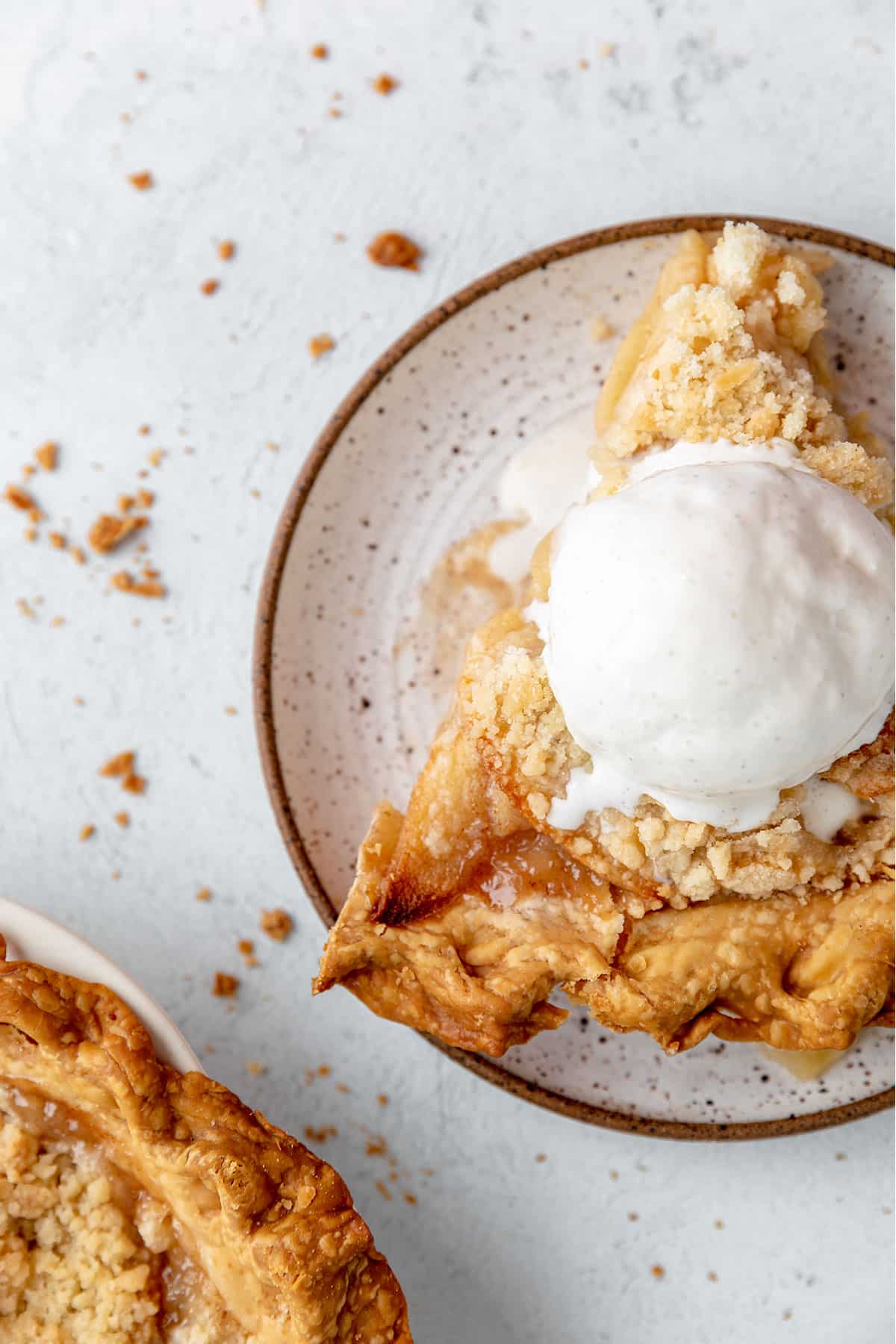 A slice of dutch apple pie served with vanilla ice cream.