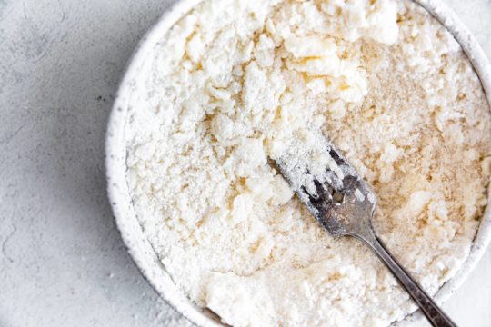 cutting butter into flour with a fork for crumb topping