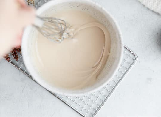 mixing vanilla glaze with a whisk