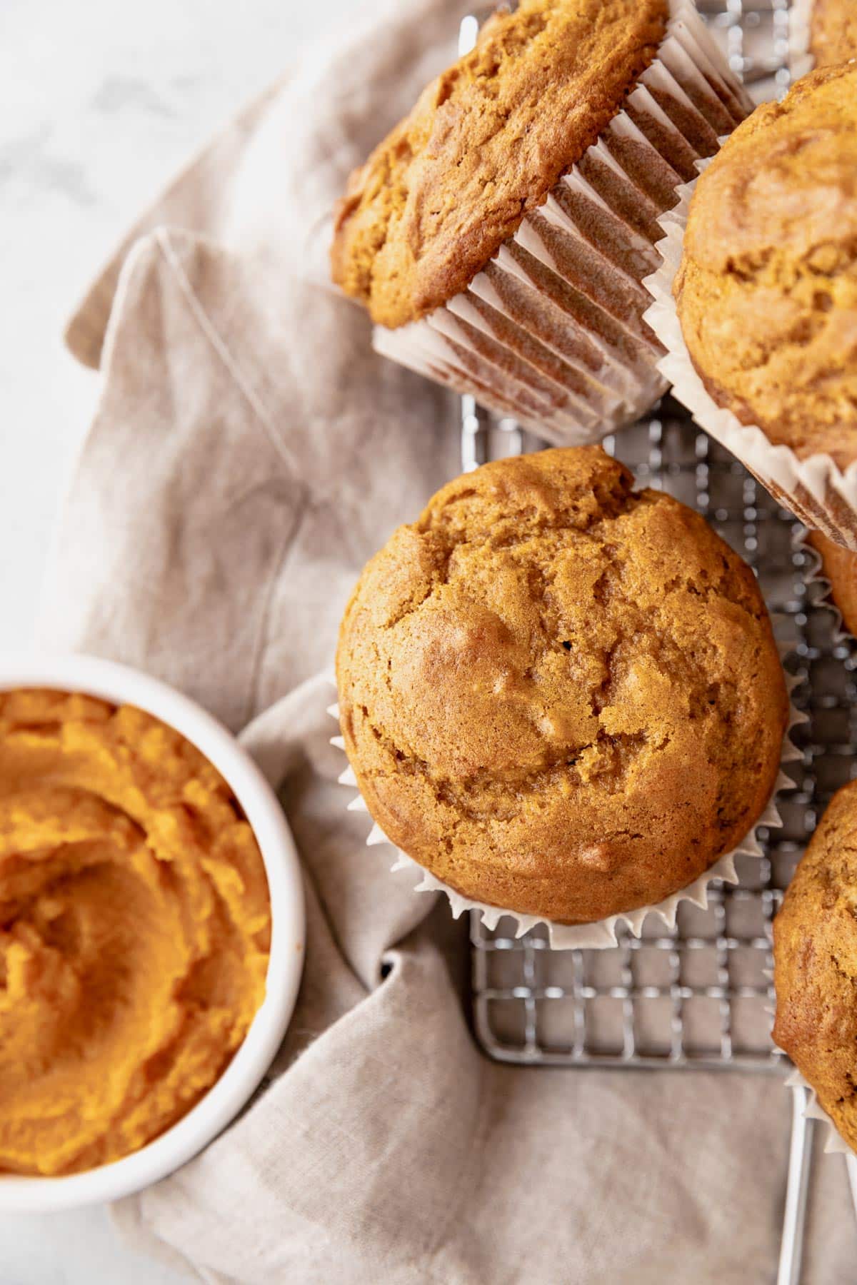 Baked pumpkin muffins on a wire cooling rack.