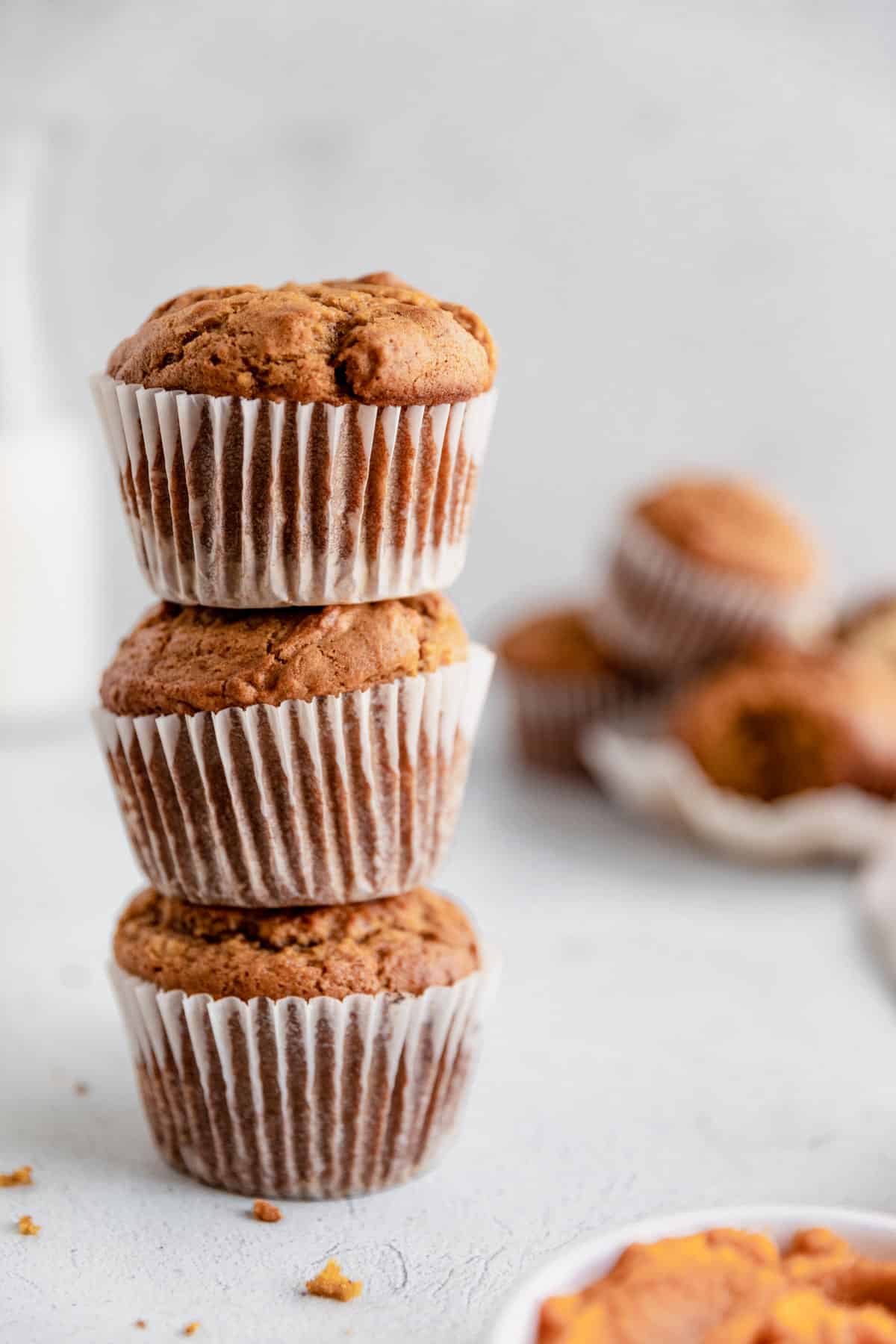 Three pumpkin muffins stacked.
