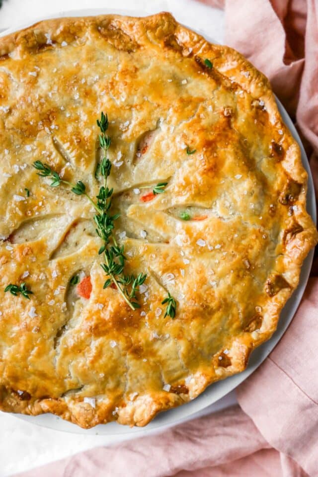 Baked chicken pot pie garnished with fresh thyme.