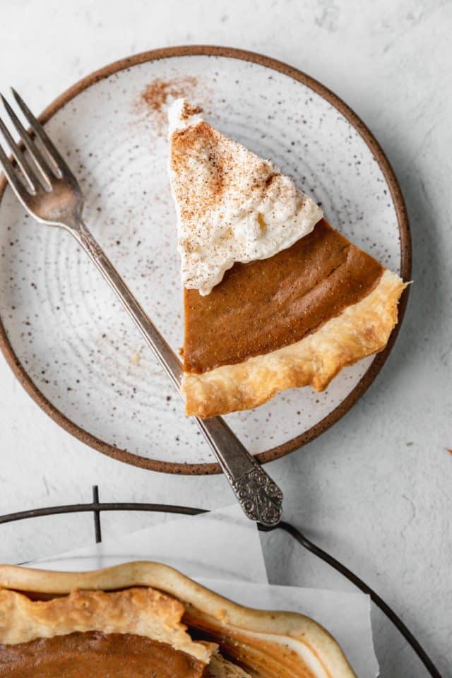 slice of pumpkin pie topped with whipped cream