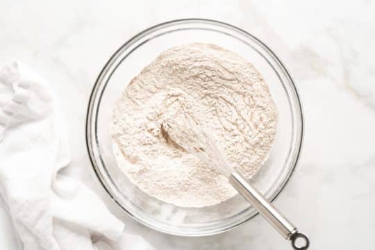 whisking together flour and other dry ingredients in a large mixing bowl
