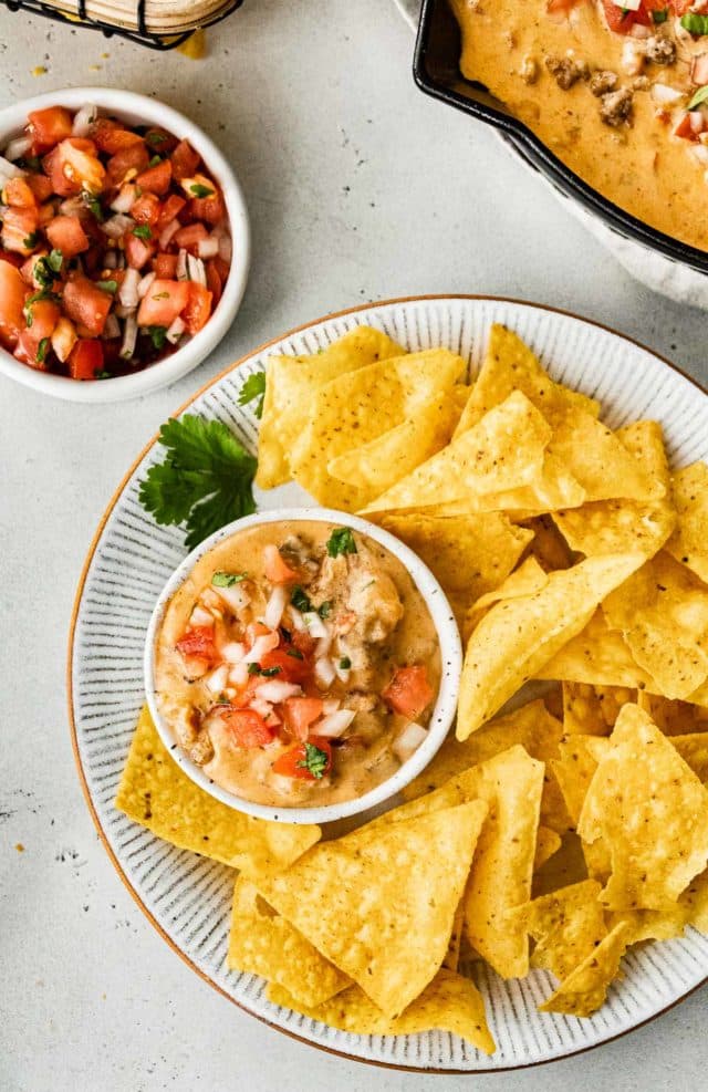 cheesy sausage dip served in a small bowl with tortilla chips