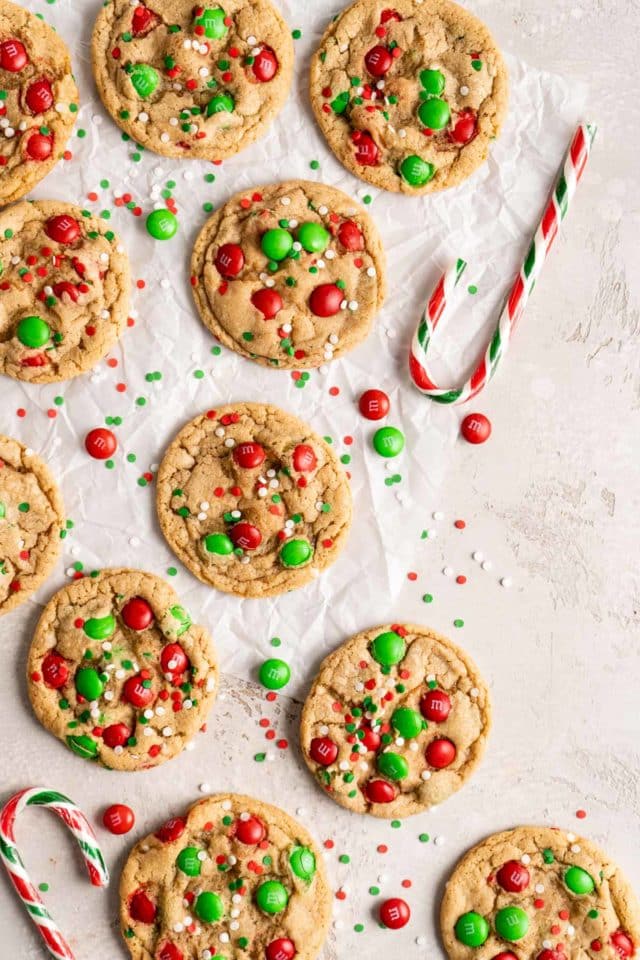 Christmas cookies on parchment paper near a candy cane