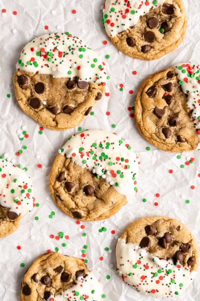 chocolate chip cookies dipped in white chocolate and sprinkled with holiday sprinkles