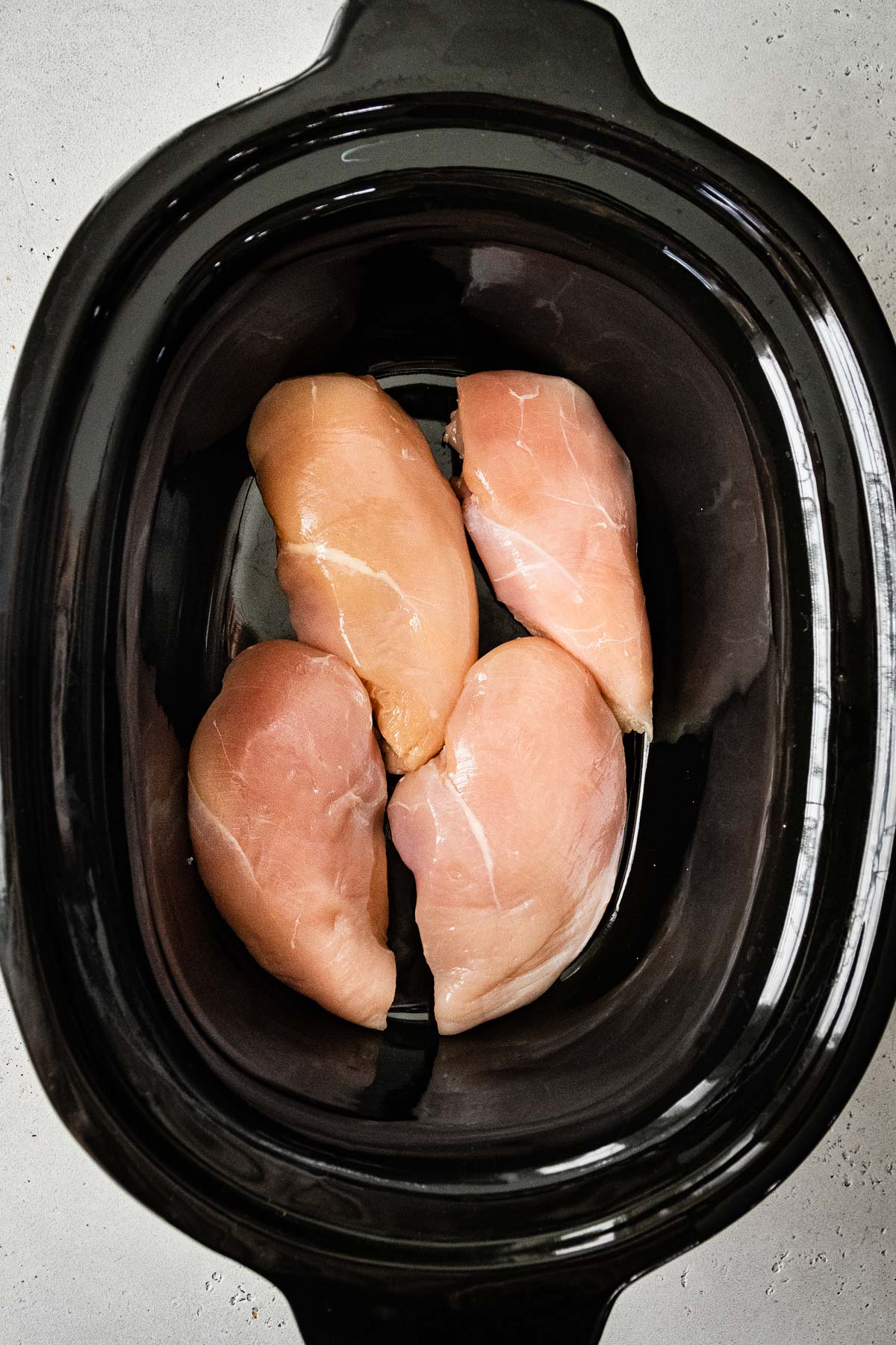 adding chicken to slow cooker