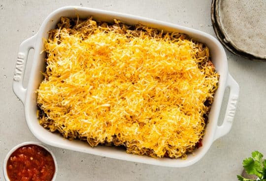 chicken recipe topped with shredded cheese in a baking dish