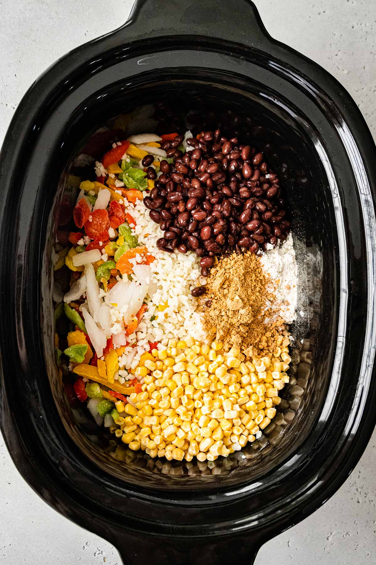 adding all ingredients to a slow cooker for Mexican chicken