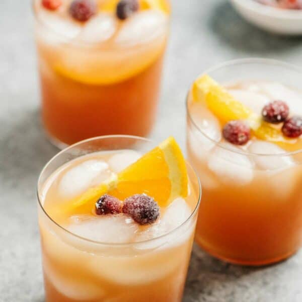 Vodka cranberry cocktail with sugared cranberries and orange slices.
