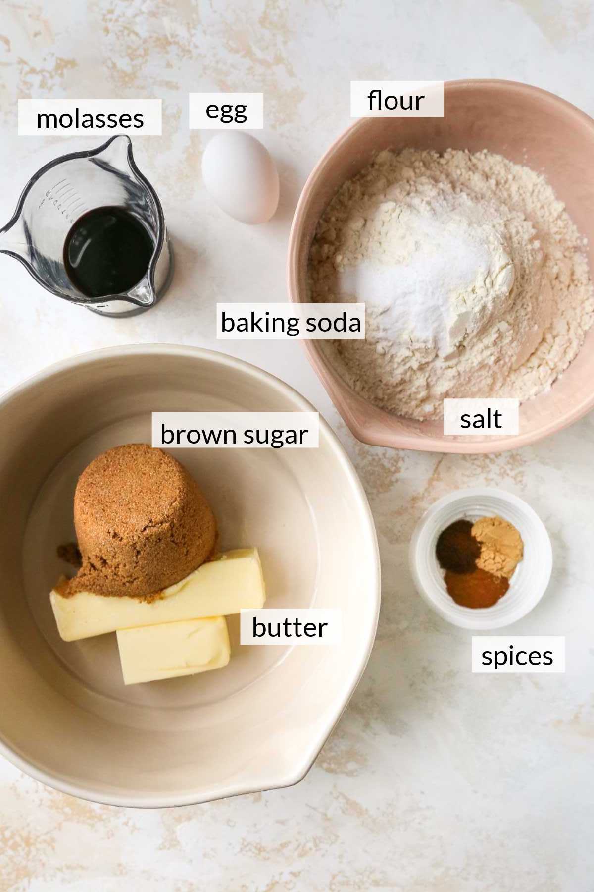 Brown sugar, butter, molasses, spices, flour, baking soda and salt divided into bowls.