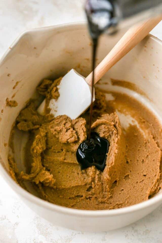 Pouring molasses into a mixture of butter and sugar.