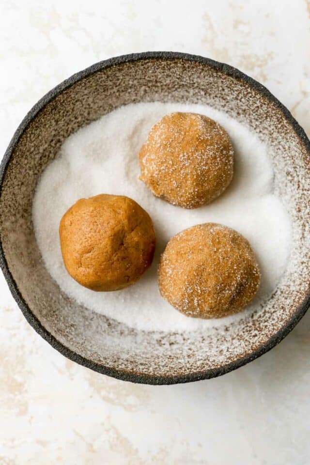 Rolling dough balls in sugar.