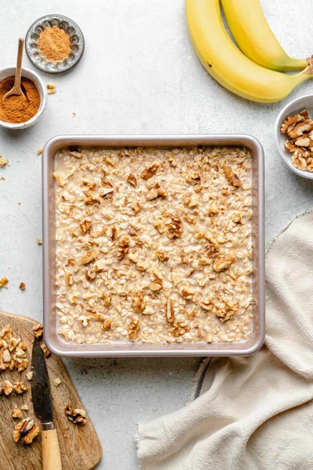 oatmeal mixture in baking pan topped with toasted walnuts