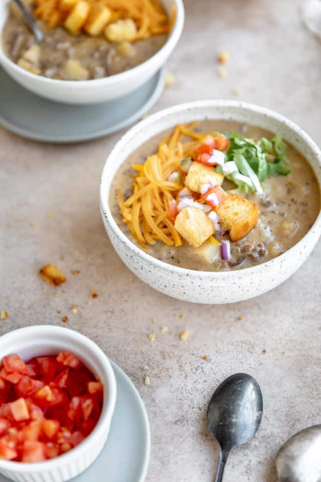 bowls of cheeseburger soup served with fresh toppings