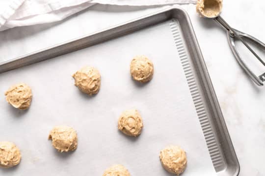 dropping spoonfuls of dough onto a cookie sheet