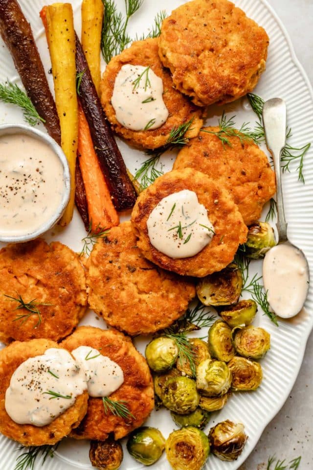 salmon patties served with carrots and Brussels sprouts