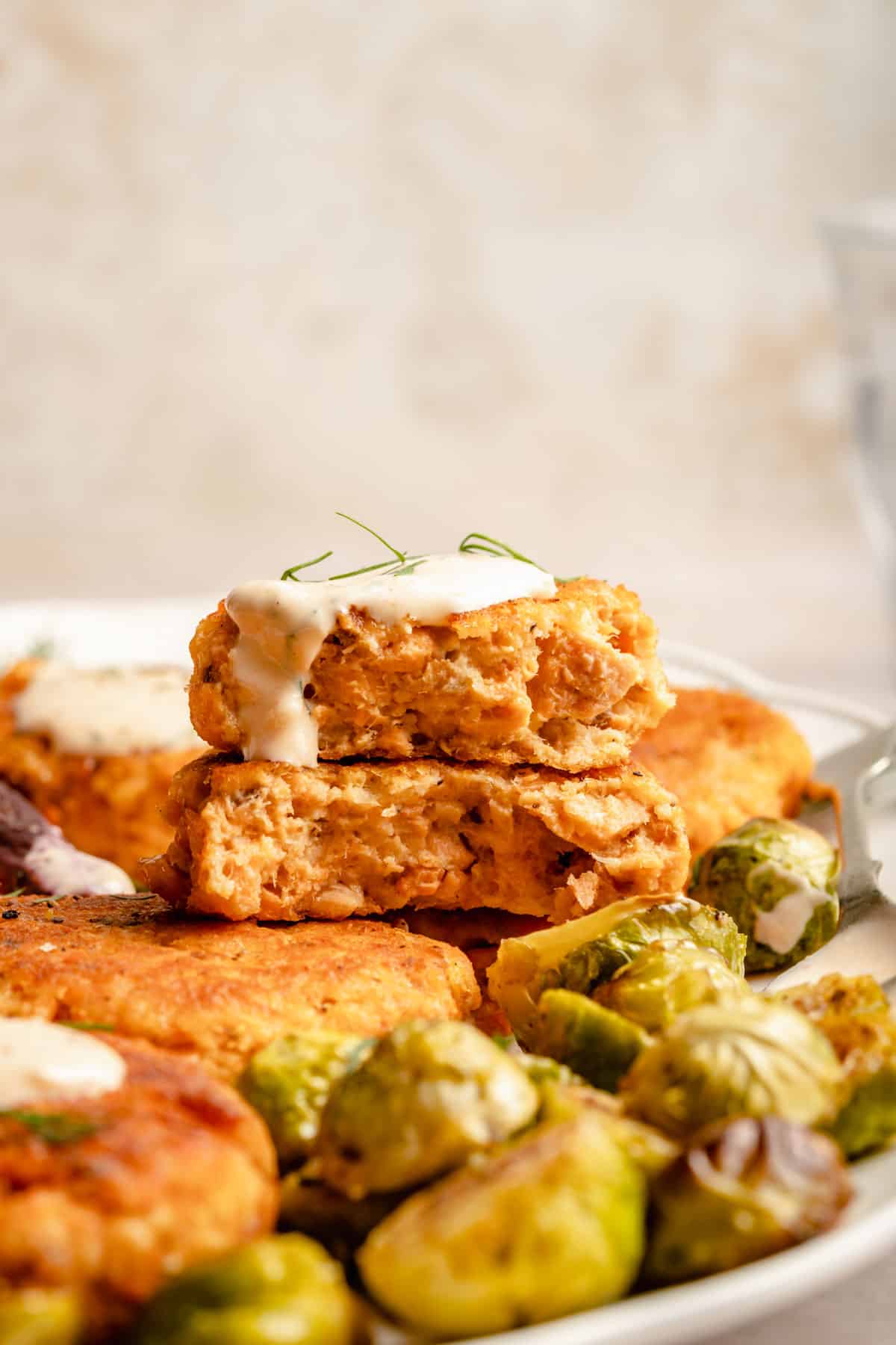 salmon patty that has been cut into and topped with sauce